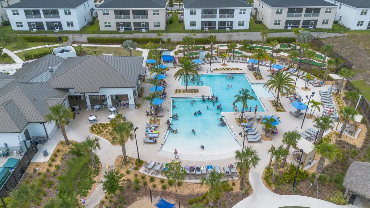 A sparkling swimming pool surrounded by palm trees and poolside lounge chairs creates a vibrant yet relaxing resort atmosphere. Children can be seen playing in the water, while adults relax nearby with drinks, evoking a sense of joyful leisure and family-friendly fun.